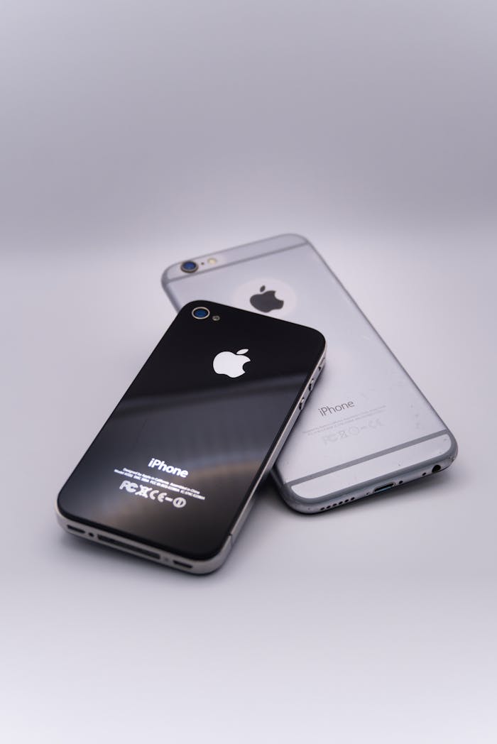 hero-img-01 Two sleek smartphones on a gray surface showcasing minimalist design and technology.